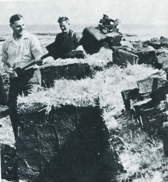 Two men harvesting peat, manually in a rural farm setting. Falkland Islanders shovelling peat in the 1950s