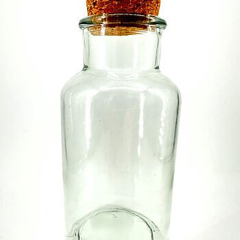 Transparent glass jar with cork stopper, minimalist design—versatile for storage and decor.