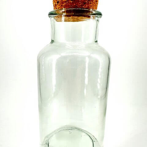 Transparent glass jar with cork stopper, minimalist design—versatile for storage and decor.