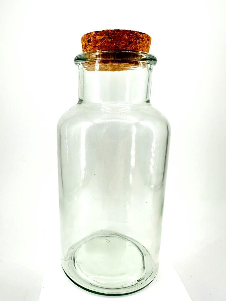 Transparent glass jar with cork stopper, minimalist design—versatile for storage and decor.