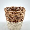 Two-toned wicker basket with plastic lining, contrasting natural brown and light woven design.