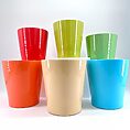 Vibrant coloured cups in a semi-circular display, showcasing glossy finishes and cheerful hues.