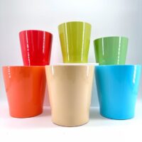 Vibrant coloured cups in a semi-circular display, showcasing glossy finishes and cheerful hues.