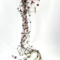 Hanging plant in white pot with cascading green and burgundy leaves.
