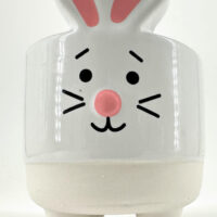 Ceramic bunny figurine with glossy finish, large eyes, pink nose, and whimsical design.
