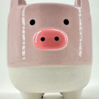 Playful ceramic pig figure with vibrant pink and white colors, glossy finish, and charming design.