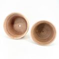 Two terracotta plant pots with drainage holes on white background.