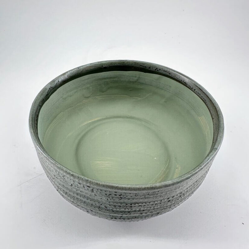 Elegant Artisan Bowl in Muted Green Artisan bowl in muted green with textured exterior and glossy interior, perfect for decor and use.
