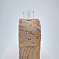 Artistic modern vase with textured design and glass top for elegant home decor.