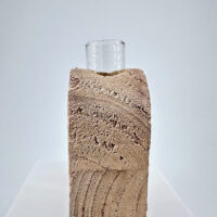 Artistic modern vase with textured design and glass top for elegant home decor.