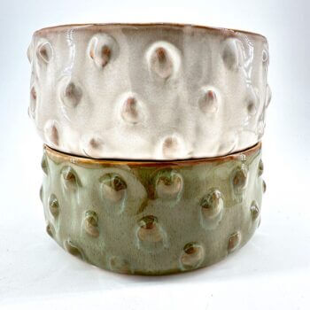 Stylish ceramic bowls in beige and green, showcasing unique textures and elegant designs.