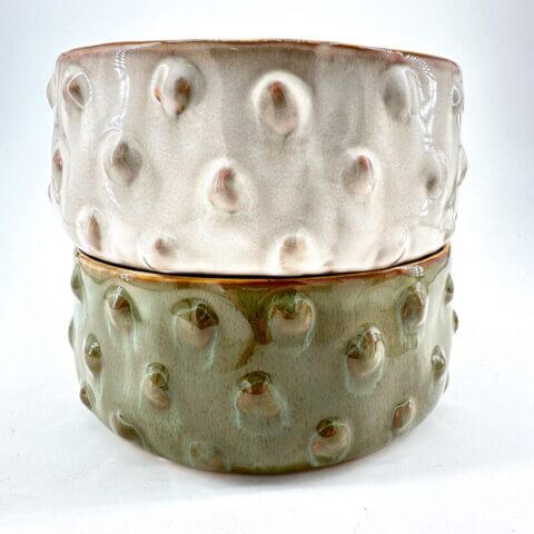 Stylish ceramic bowls in beige and green, showcasing unique textures and elegant designs.