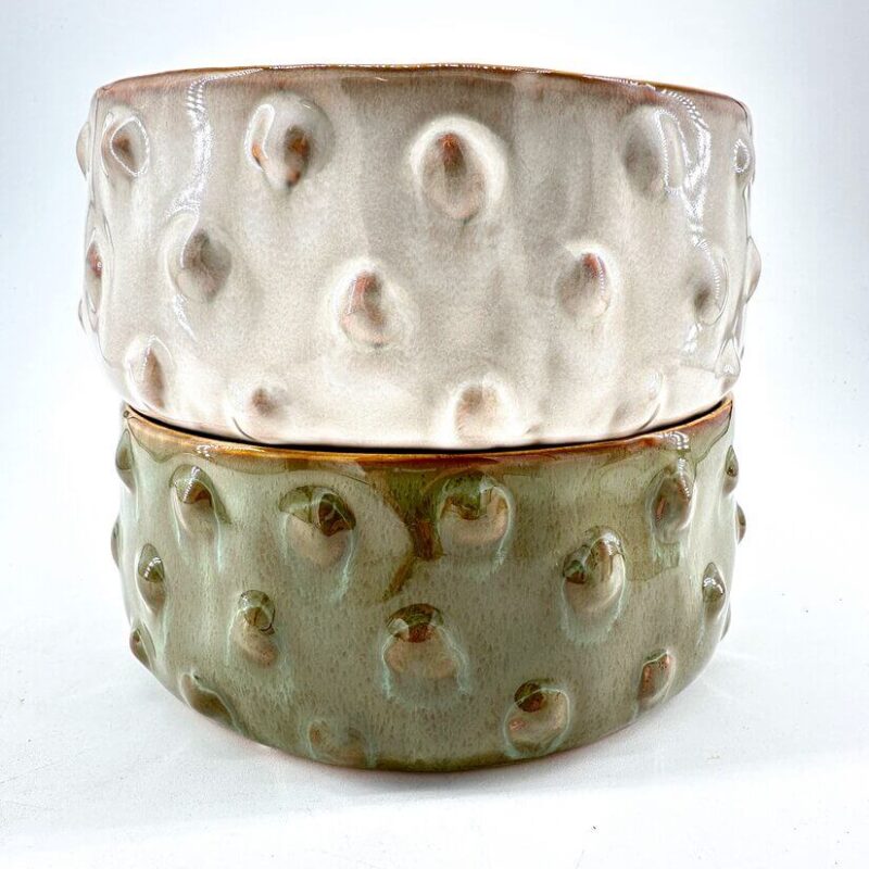 Stylish ceramic bowls in beige and green, showcasing unique textures and elegant designs.
