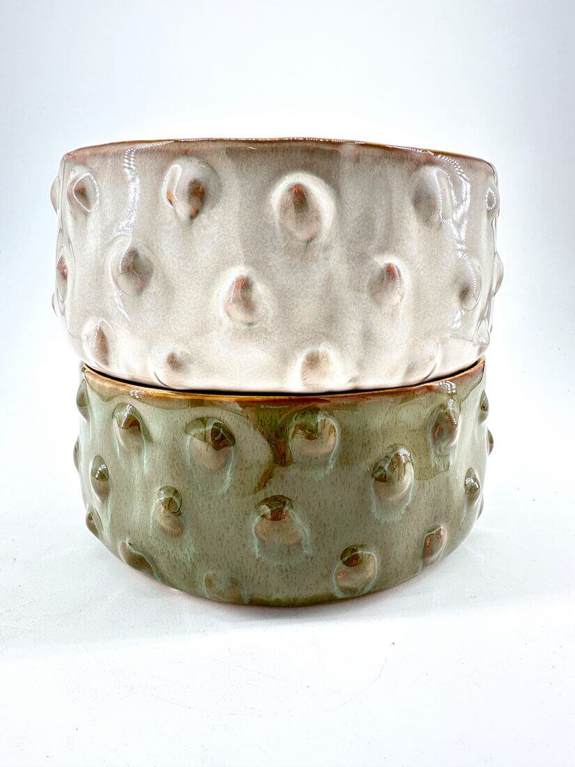Stylish ceramic bowls in beige and green, showcasing unique textures and elegant designs.