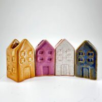 Charming ceramic house figurines in vibrant colours, perfect for home decor and nostalgic collections.