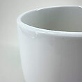 Glossy white ceramic planter with elegant curves, perfect for home decor and indoor plants.