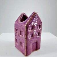 Whimsical lavender ceramic house sculpture perfect for home decor or as a charming planter.