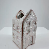 Whimsical lavender ceramic house vase, perfect for charming home decor and floral displays.