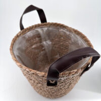 Stylish woven basket with leather handles, perfect for home storage and decor.