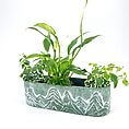 Elegant indoor planter with greenery showcasing Peace Lily and vibrant plants in artistic pot.