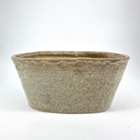 Rustic ceramic pot with textured beige surface and elegant wavy rim for decorative use.