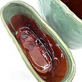 Elegant ceramic vessels in mint-green and reddish-brown glazes, showcasing exquisite craftsmanship and design.