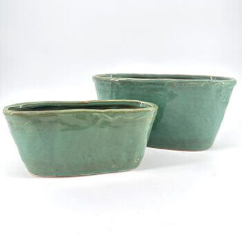 Elegant ceramic teal pots with a glossy finish, perfect for indoor plants and decor.