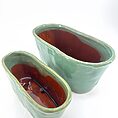 Stylish ceramic planters in green and terracotta, perfect for home decor and floral arrangements.