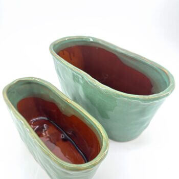 Stylish ceramic planters in green and terracotta, perfect for home decor and floral arrangements.