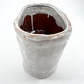 Unique handcrafted ceramic vase with organic shape, glossy finish, and earthy colour variations.
