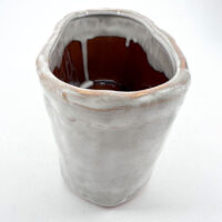 Unique handcrafted ceramic vase with organic shape, glossy finish, and earthy colour variations.