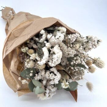 Charming dried flower bouquet in rustic paper, perfect for natural home décor and gifts.