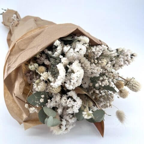 Charming dried flower bouquet in rustic paper, perfect for natural home décor and gifts.