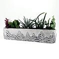 Stylish succulent planter in textured concrete with diverse green plants and artistic mountain design.