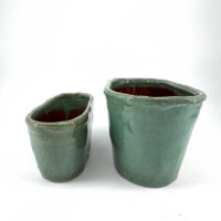 Handcrafted ceramic pots with turquoise glaze, showcasing unique textures and rustic charm.