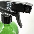Close-up of a vibrant green spray bottle with a black nozzle for efficient dispensing.