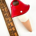 Whimsical ceramic ice cream cone with red scoop and antique ruler for scale.