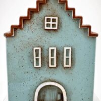 Charming miniature blue house with rustic design, zigzag roof, and white-framed windows.