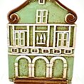 Charming decorative green house with whimsical design and European architectural elements.