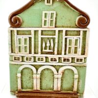 Charming decorative green house with whimsical design and European architectural elements.