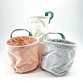 Trio of colourful fabric storage baskets with textured design and green handles.