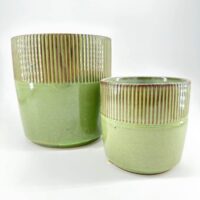 Green ceramic pots with ribbed texture, glossy finish, set against white background.