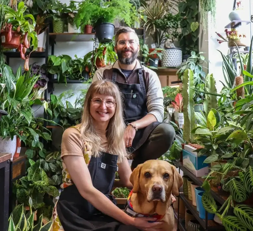Indoor plant lovers with dog; vibrant home garden atmosphere.