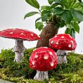 Enchanting red mushrooms on green moss in a whimsical, miniature forest scene.