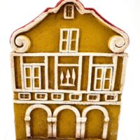 Miniature yellow building with red roof, whimsical decorative piece, ceramic architectural art.
