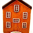 Charming miniature orange house figurine with rustic details and contrasting white framed windows.
