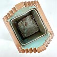 Terracotta square pot with mint green interior, geometric design, modern and rustic textures.