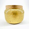 Glossy yellow ceramic jar with cork lid, speckled texture, modern decor.