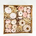 Box of assorted decorative seashells on straw, perfect for beach-themed decor or crafts.