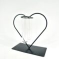 Heart-shaped metal frame with glass test tubes, blending science and romance in decorative art.